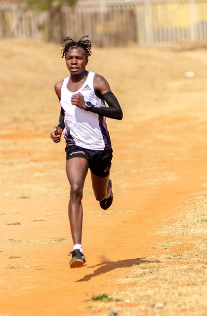 A young boy running fast in a park.
