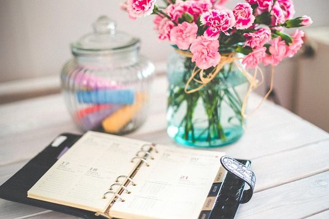 A person checking entries in their daily planner notebook.