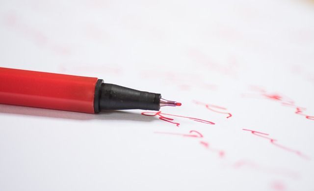 Close up of a person hand-writing a business report on paper with a pen.