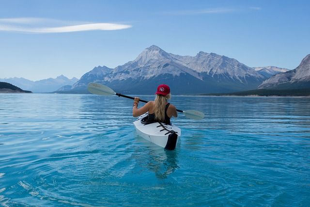 A person paddling a kayak on scenic open water