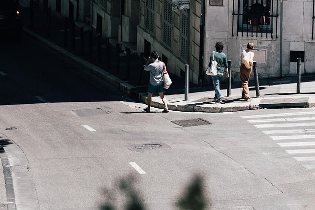 A pedestrian walking across a zebra crossing on a city street.