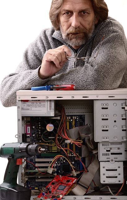 A technician repairing a desktop computer in a workshop