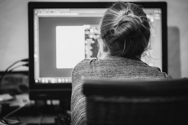 A female graphic designer working on graphic software at her workstation.