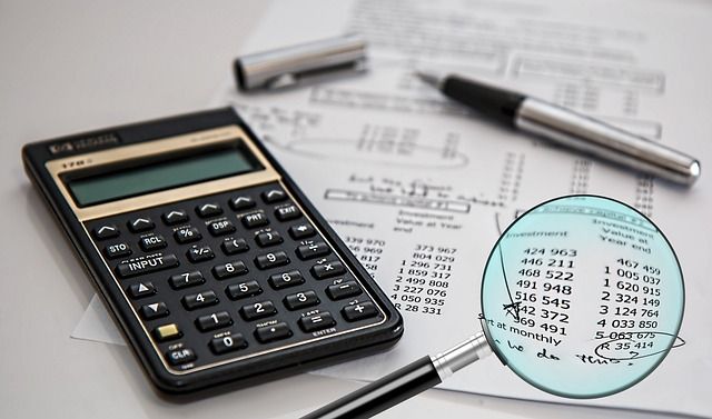 An auditor examining financial paperwork with a highlighter and pen