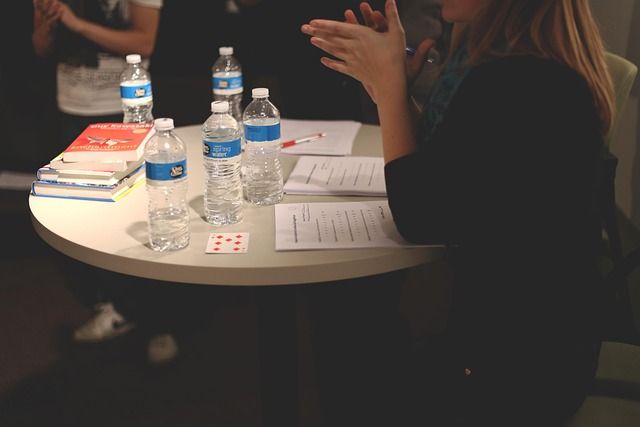 A group of people sitting around a circular table in an office meeting.