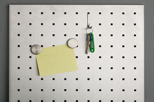 A hand attaching a sticky note onto a board.