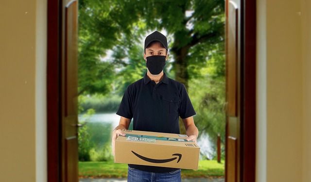 A courier delivering a cardboard package at a house entrance.