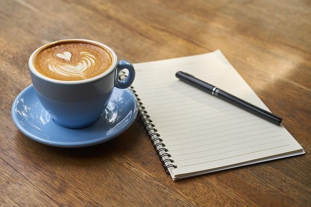 A person pouring coffee into a cup in an office kitchen.