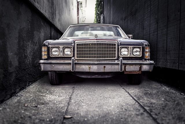 A car carefully reversing down a narrow backstreet.